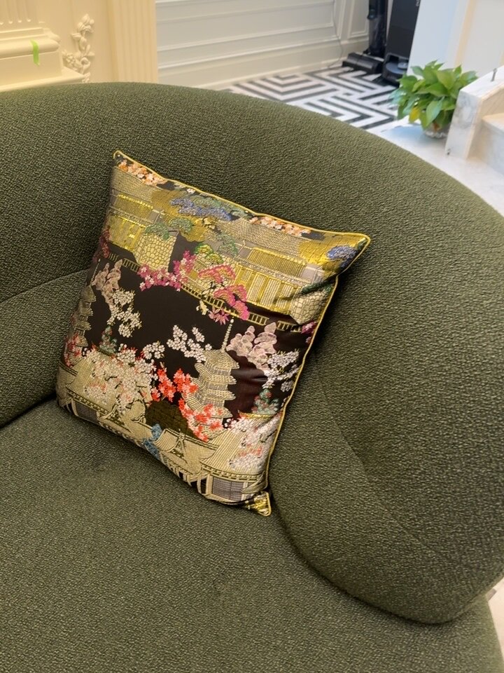Close-up of gold metallic embroidery showing flowering trees and pavilion details on burgundy velvet cushion