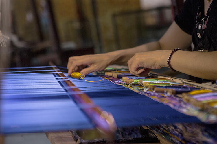 云锦博物馆的展示区域中,多名织工在进行着云锦的织造,游客可以近距离