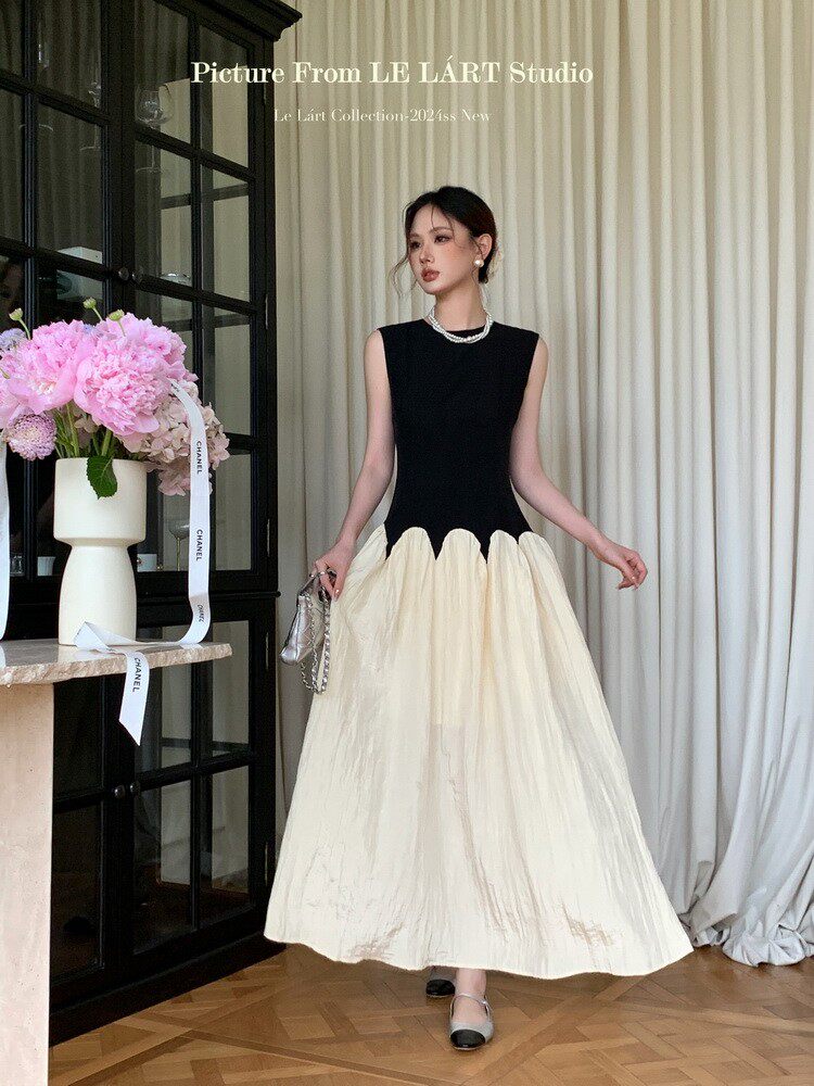 Sleeveless black-and-cream long dress worn by a model indoors