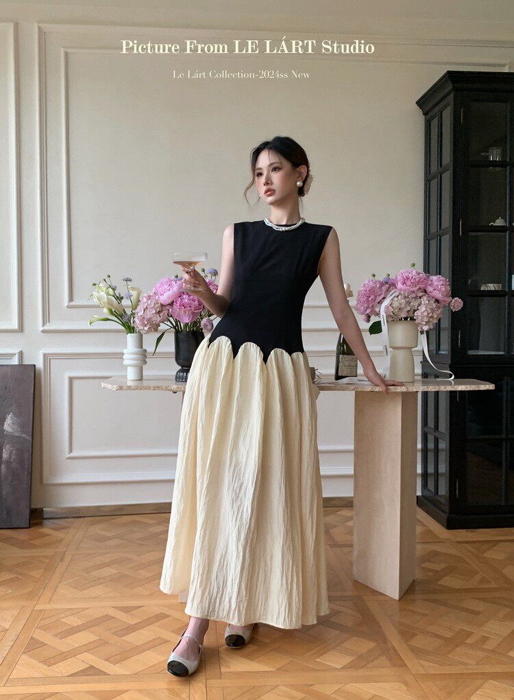 Model wearing a sleeveless black-and-cream maxi dress indoors