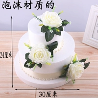 Круглый белый торт с тремя белыми розами.