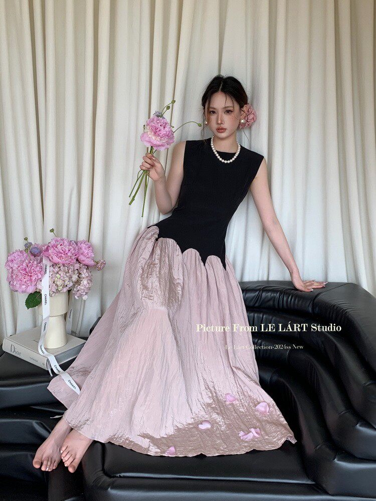 Model wearing a black and blush pink sleeveless long dress with floral accents
