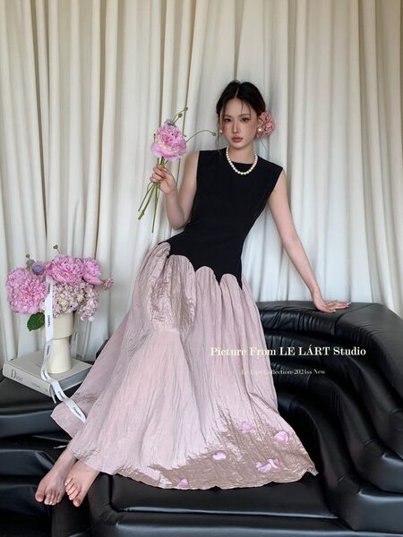 Model wearing a black and blush pink sleeveless long dress with floral accents