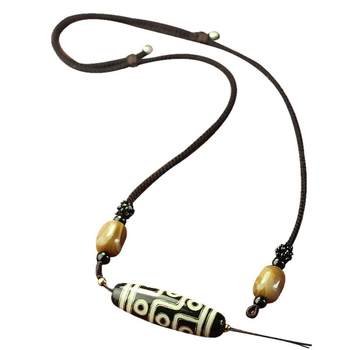 Dzi bead lanyard is hand-woven across the collarbone of the halter neck