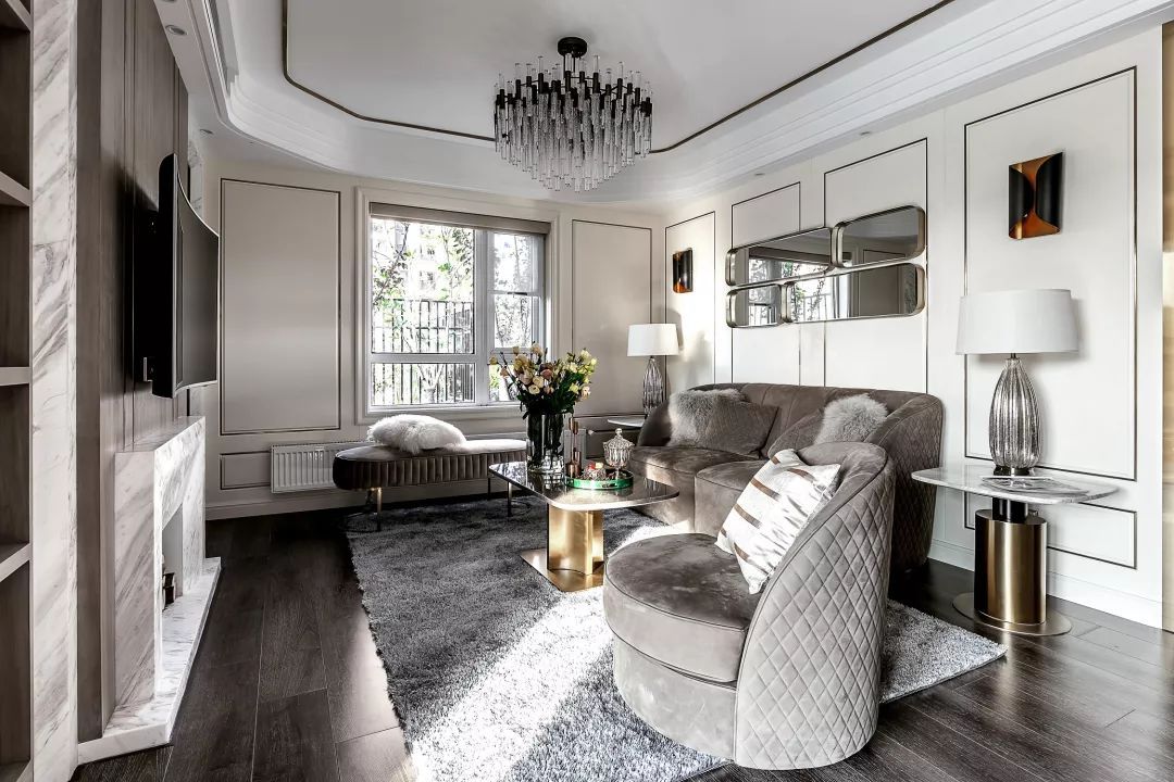 客厅采用圆弧形吊顶搭配水晶吊灯,再配以灰色系沙发,给人一种高档之感