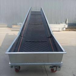 Lifting bulk material conveyor with fence